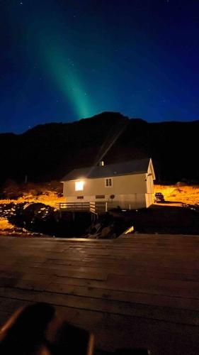 a building with a green light in the sky at Rorbu Vestersia i Skjelfjord in Ramberg