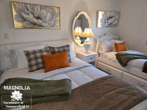 a bedroom with two beds and a mirror at Magnolia Farmhouse at Summerfield NC in Summerfield