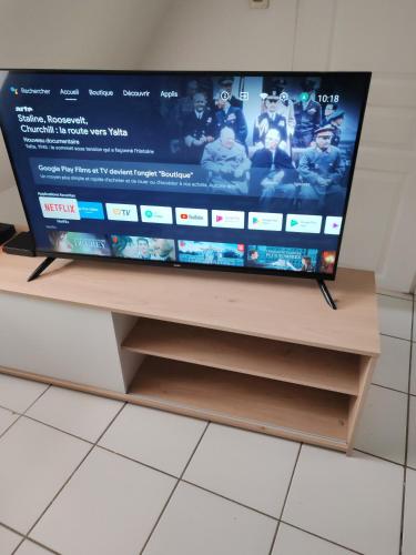 a flat screen tv sitting on top of a tv stand at APPARTEMENT FRIZEBOIs in Soissons