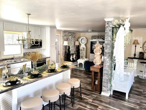 a kitchen with a counter and stools in a room at Magnolia Farmhouse at Summerfield NC in Summerfield