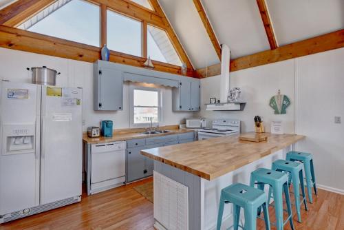 a kitchen with white appliances and blue stools at 2003 N Shore Drive - Sunbeams Ocean Dreams in West Onslow Beach