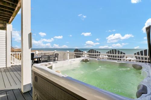 a hot tub on a deck with the beach in the background at 1322 New River Inlet Road- Oceanfront, 240 EV outlet, Elevator, Sleeps 18, Hot tub in North Topsail Beach