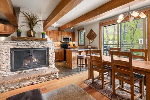 ein Wohnzimmer mit einem Kamin, einem Tisch und Stühlen in der Unterkunft Chateau Roaring Fork 22, Mountain Chic 4-Bedroom Condo on Roaring Fork River – Walk to Downtown Aspen in Aspen