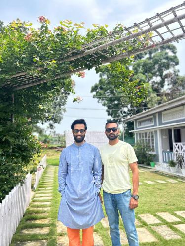 two men standing next to each other in a yard at Sunny Villa in Sivasagar
