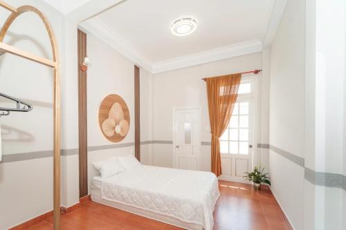 a white bedroom with a bed and a window at Ngân Villa in Xuan An