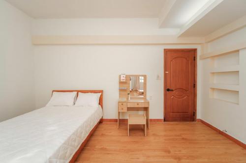 a bedroom with a bed and a desk and a drawer at Ngân Villa in Xuan An