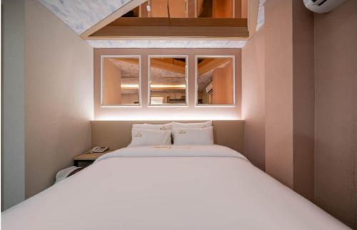 a bedroom with a large white bed in a room at hotel louize in Seoul