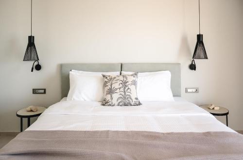 a bedroom with a large white bed with two tables at Batis Beach Hotel in Rethymno Town