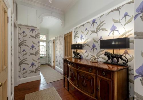 a hallway with purple flowers on the wall at The Lauderdale Street Residence in Edinburgh