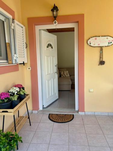 a room with a door and a table with flowers at Louloudi Apartment in Tsilivi