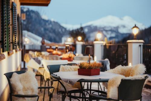 a balcony with tables and chairs with mountains in the background at Stella Due in Arabba