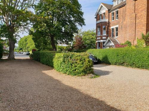 a sidewalk in front of a building with a hedge at The Wycliffe in Folkestone