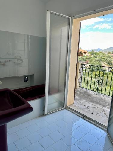 d'une cuisine avec une porte coulissante en verre s'ouvrant sur un balcon. dans l'établissement Villa Passiflore with garden and private swimming pool, à Nice