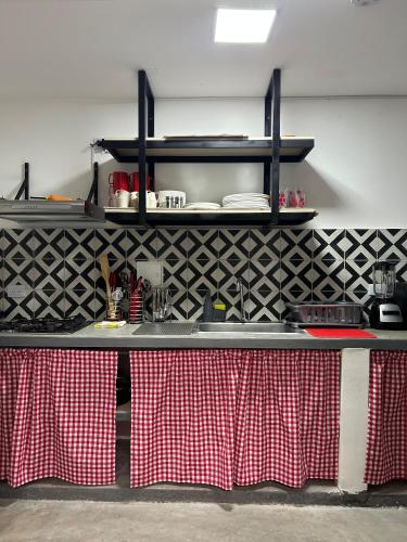 a kitchen counter with red and white checkered tables at Nómada22 -Hostal moderno en el centro de Neiva in Neiva