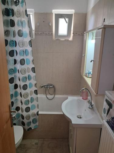 a bathroom with a sink and a shower curtain at Liberty Cozy Apartment in Kalloni
