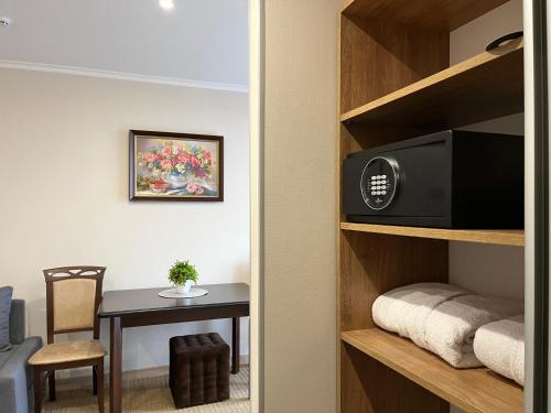 a room with a table and a television on a book shelf at "Гірський Континент" Hotel Restaurant & SPA in Yablunytsya