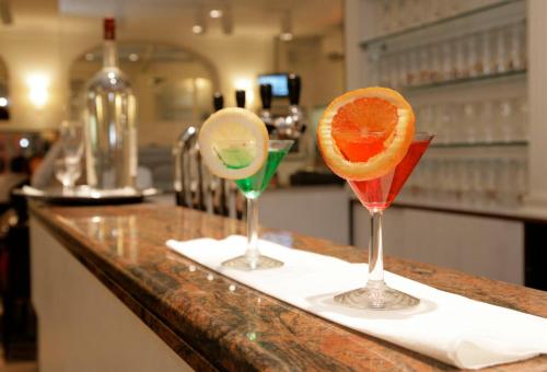 two martini glasses with an orange slice on a counter at Ambassador-Monaco in Monte Carlo