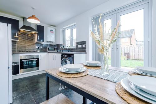 una cucina con tavolo in legno e piatti di Steps from O2 Apollo, Ox road a Manchester