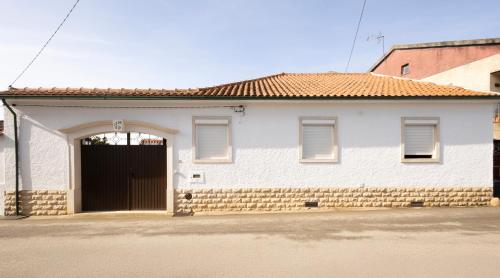 a white house with a black door and windows at Casa Benny Countryside Guesthouse CENTER PORTUGAL in Hombres