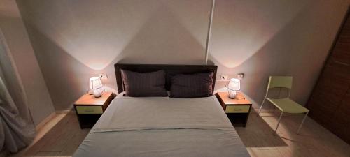 Un dormitorio con una cama y dos lámparas sobre dos mesas. en Sal service green moradias residence with pool, en Santa Maria