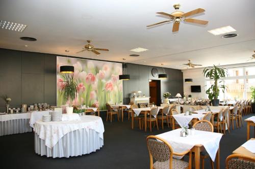 a dining room with tables and chairs and a large screen at Hotel Pflug in Ottenhöfen
