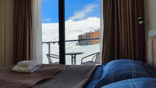 a bedroom with a view of a snowy mountain from a window at GVC New Gudauri Twins 413 Mountain View in Gudauri