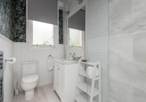 a white bathroom with a toilet and a sink at The Lauderdale Street Residence in Edinburgh