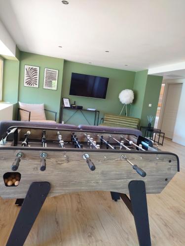 a ping pong table in a living room at Le Panoramique du Plongeoir - T4 spacieux de 90m2 avec grande terrasse vue sur le lac de Serre Ponçon in Savines