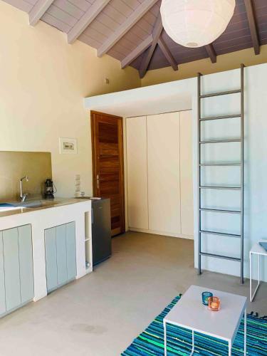 a room with a kitchen with a table and a sink at A designed loft studio a minute walk to the beach in Archangelos