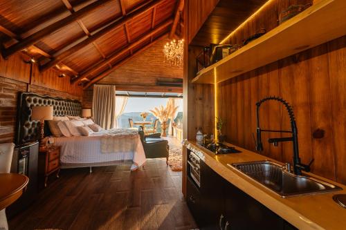 a kitchen with a sink and a bed in a room at Morada Valente in Gramado