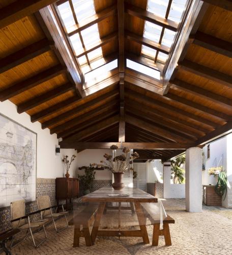 a large room with a wooden ceiling with a table at Casa Benny Countryside Guesthouse CENTER PORTUGAL in Hombres