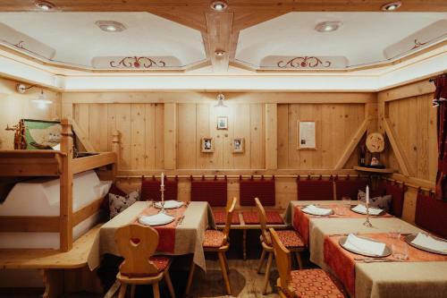 a restaurant with wooden walls and tables and chairs at Stella Due in Arabba