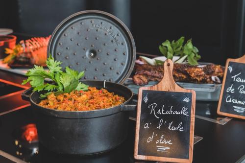 a table topped with a pot of food and signs at Campanile PRIME - Nice Airport in Nice