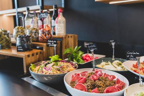 a buffet with several plates of food on a counter at Campanile PRIME - Nice Airport in Nice