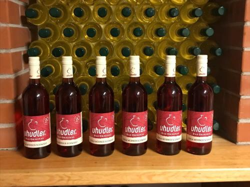 a group of four bottles of wine on a shelf at Modernes Kellerstöckl im Südburgenland in Glasing