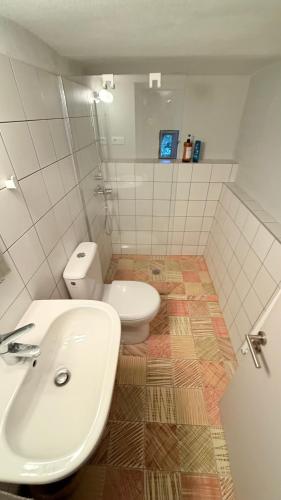 une salle de bain avec des toilettes blanches et un lavabo dans l'établissement Le cabanon du Faron une chambre d hote dans un jardin, à Toulon