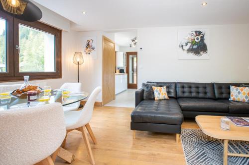 un salon avec un canapé en cuir noir et une table dans l'établissement Peaceful Morzine Escape with Garden & Hot Tub, à Morzine