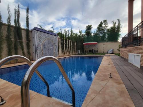 a swimming pool in a yard with a fence at Villa Marrakech Rimass - 6 Chambres Dont 5 Suites Luxe, Piscine Privee & Jardins in Marrakech