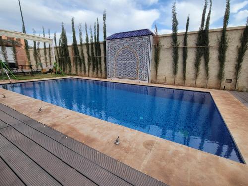 a swimming pool in front of a fence with a tileificialificialificialificialificial at Villa Marrakech Rimass - 6 Chambres Dont 5 Suites Luxe, Piscine Privee & Jardins in Marrakech