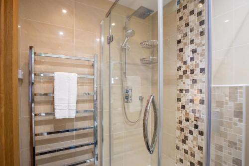 une douche avec une porte vitrée dans une salle de bain dans l'établissement Peaceful Morzine Escape with Garden & Hot Tub, à Morzine