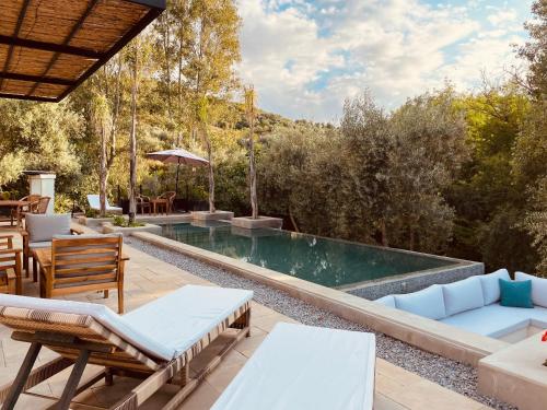 a swimming pool with chairs and a patio at CASA ULIVO villa en pleine nature in Dar Caïd Bou Driss