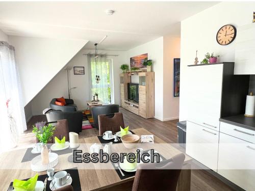 パーペンブルクにあるFerienwohnung "Neptun" Papenburg Balkon Einbauküche Neubau 74 qm Free WiFi 2 Schlafzimmer bis 4 Personenのテーブルと椅子のあるキッチンとリビングルーム