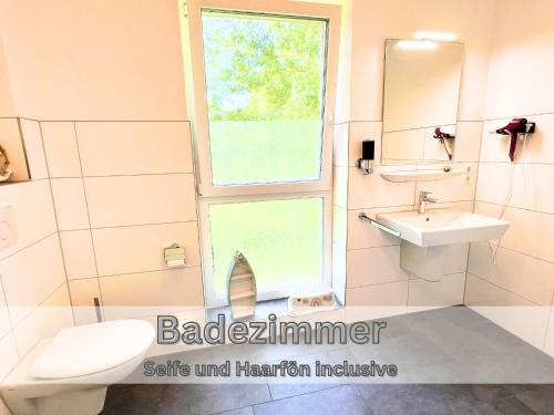 パーペンブルクにあるFerienwohnung "Neptun" Papenburg Balkon Einbauküche Neubau 74 qm Free WiFi 2 Schlafzimmer bis 4 Personenの洗面台、トイレ、窓のあるバスルーム