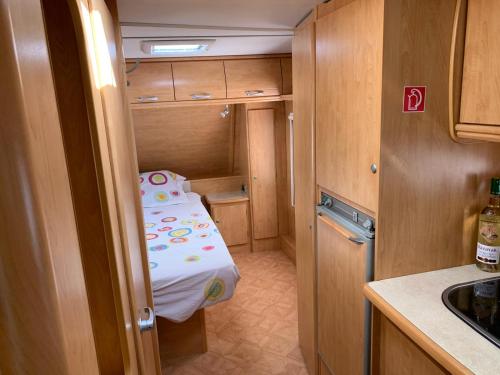 a small room with a small bed in a kitchen at Przyczepa kempingowa Happy Place Hel - Camping Kormoran in Hel