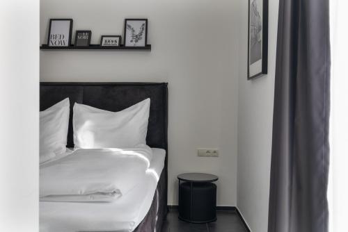 a bedroom with a bed with white sheets at Motel by Maier Feldkirch - kontaktloser Check-in in Feldkirch
