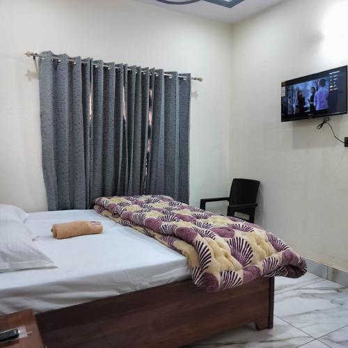 a bedroom with a bed with a blanket on it at Hotel Grand View in Barkot