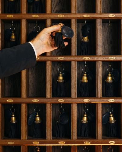 a person holding a camera in front of a wall of bells at Hôtel Balzac Paris & Spa Ikoï in Paris