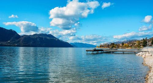 un quai sur un lac avec des montagnes en arrière-plan dans l'établissement LX136 Studio cosy avec balcon & montagne - Central, à Aix-les-Bains