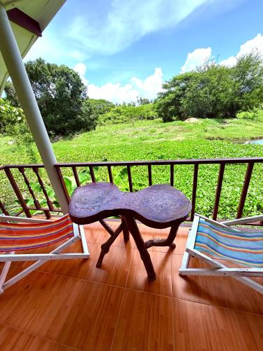 a purple bench sitting on a porch with two chairs at Wandee Resort Bankrut in Ban Krut
