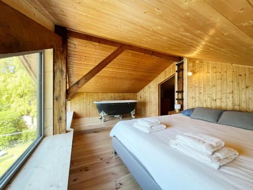 a bedroom with a bed and a bath tub at Chalet les pieds dans l'eau avec accès direct au Lac d'Annecy in Angon